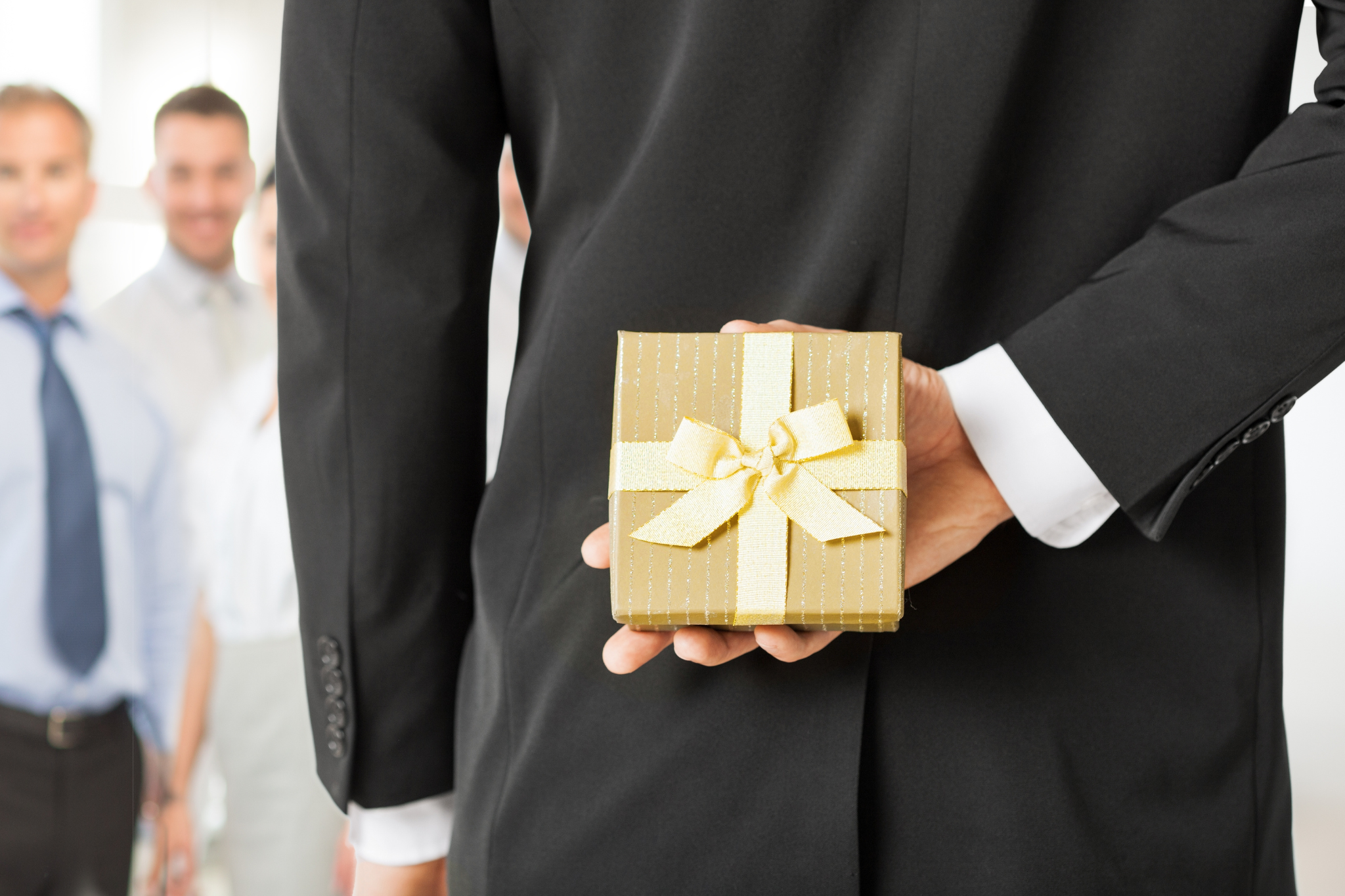businessman passing out holiday gift to employee